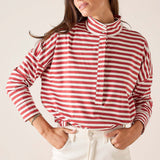 Woman wearing a red and white striped shirt with a plain background