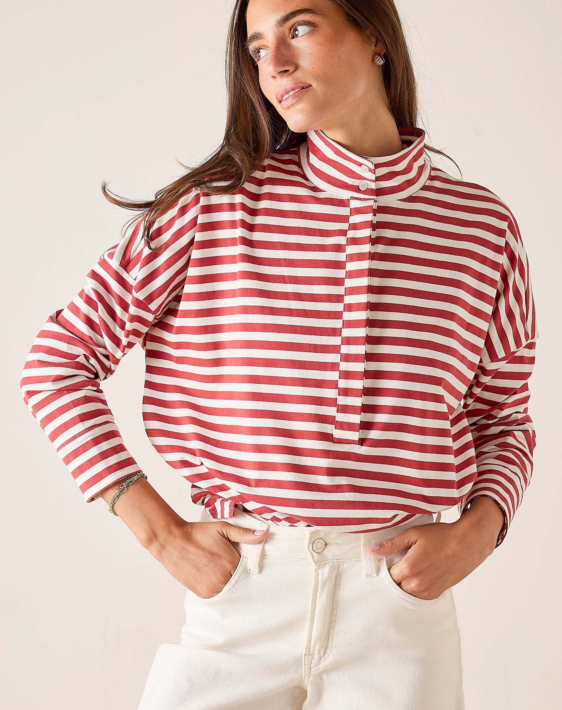 Woman wearing a red and white striped shirt with a plain background