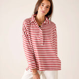 Model wearing an oversized red and white striped pop-up collar knit top with white pants.