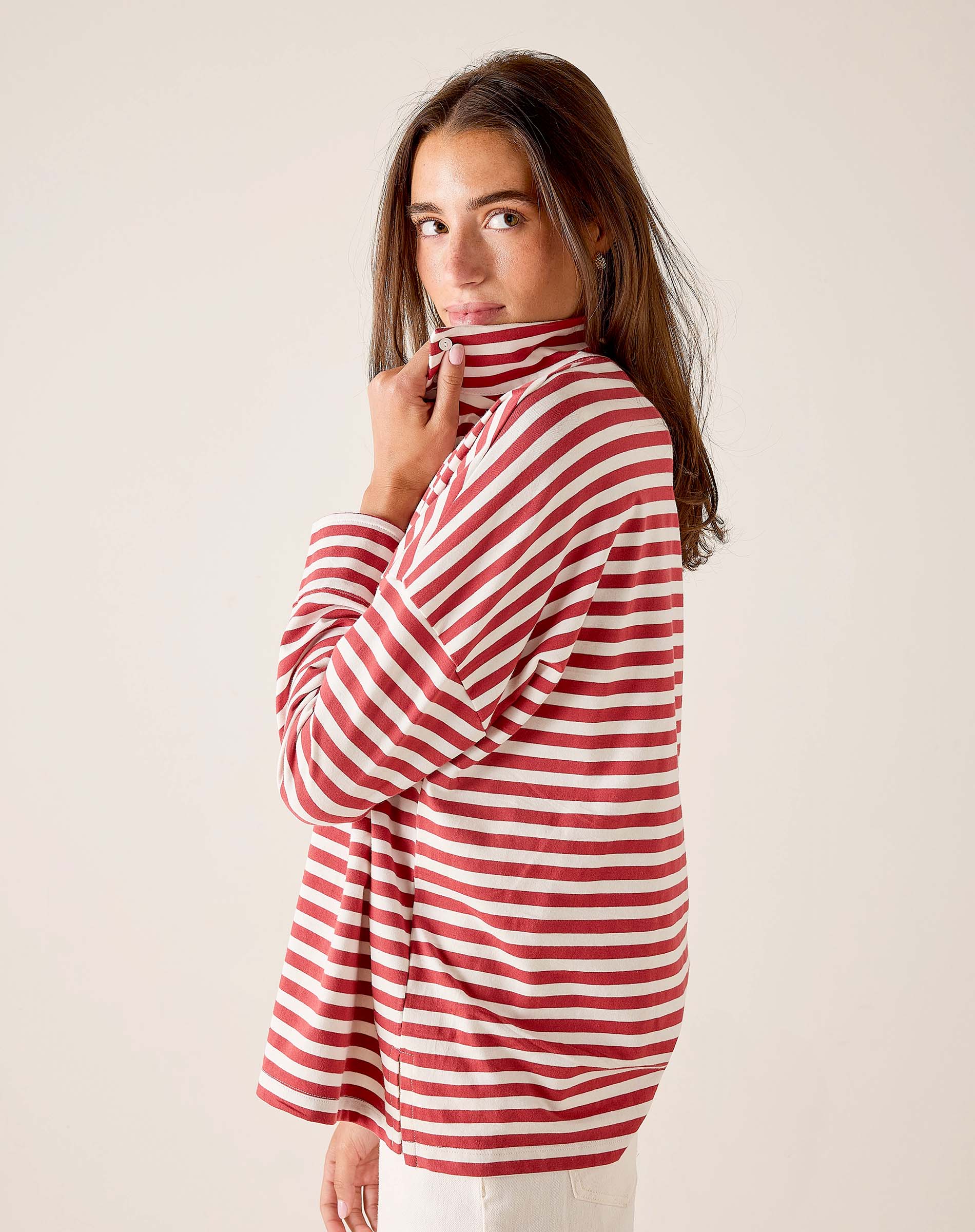Woman wearing a red and white striped shirt against a plain background