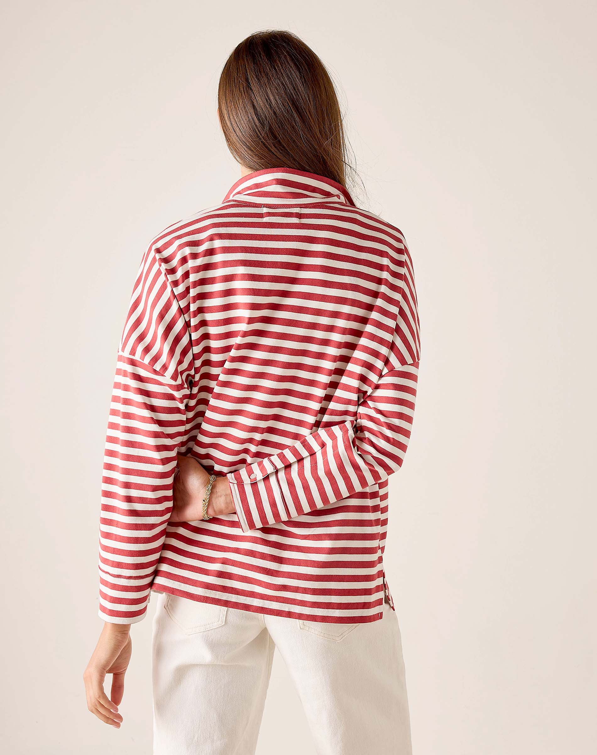 Person wearing a red and white striped shirt against a plain background