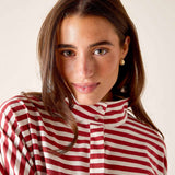 Woman wearing a red and white striped shirt against a plain background
