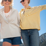 Two women wearing hoodies with a scenic background