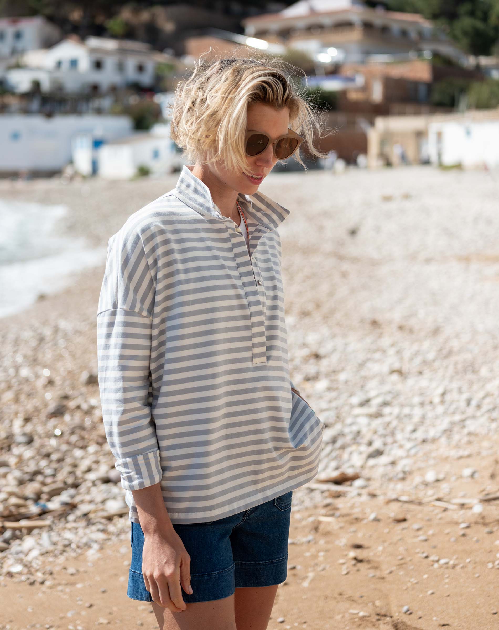 Woman wearing a striped shirt and sunglasses on a beach