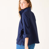 Woman wearing a navy blue jacket and blue jeans on a white background