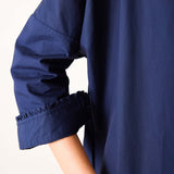 Navy blue garment with rolled-up sleeves on a white background