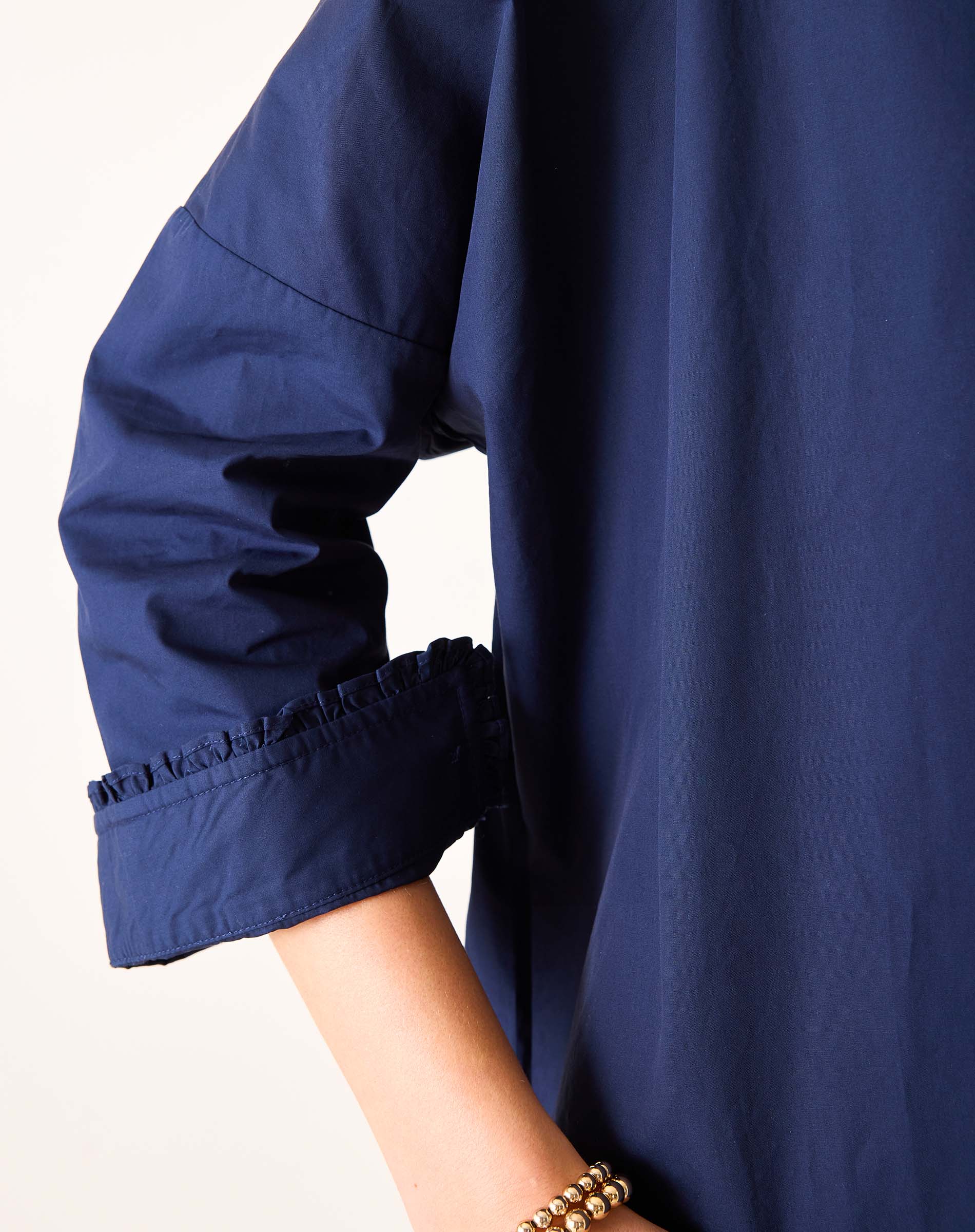Navy blue garment with rolled-up sleeves on a white background