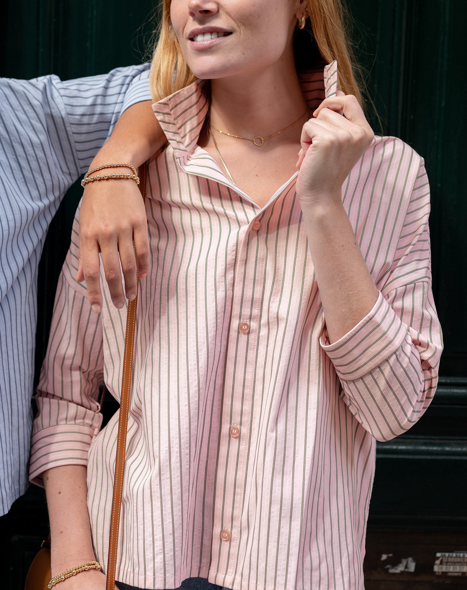 Woman wearing a pink striped shirt with a blurred background