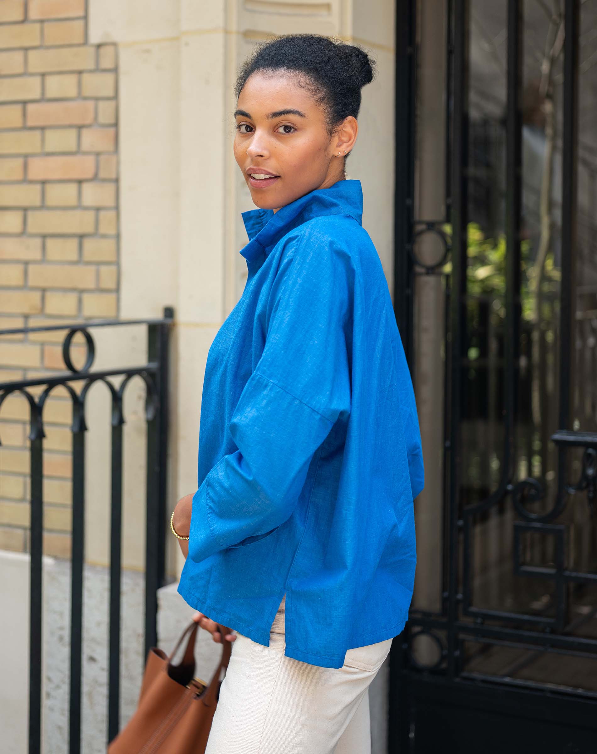 Woman wearing a blue jacket standing outside a building.