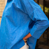 Person wearing a blue shirt with a blurred background