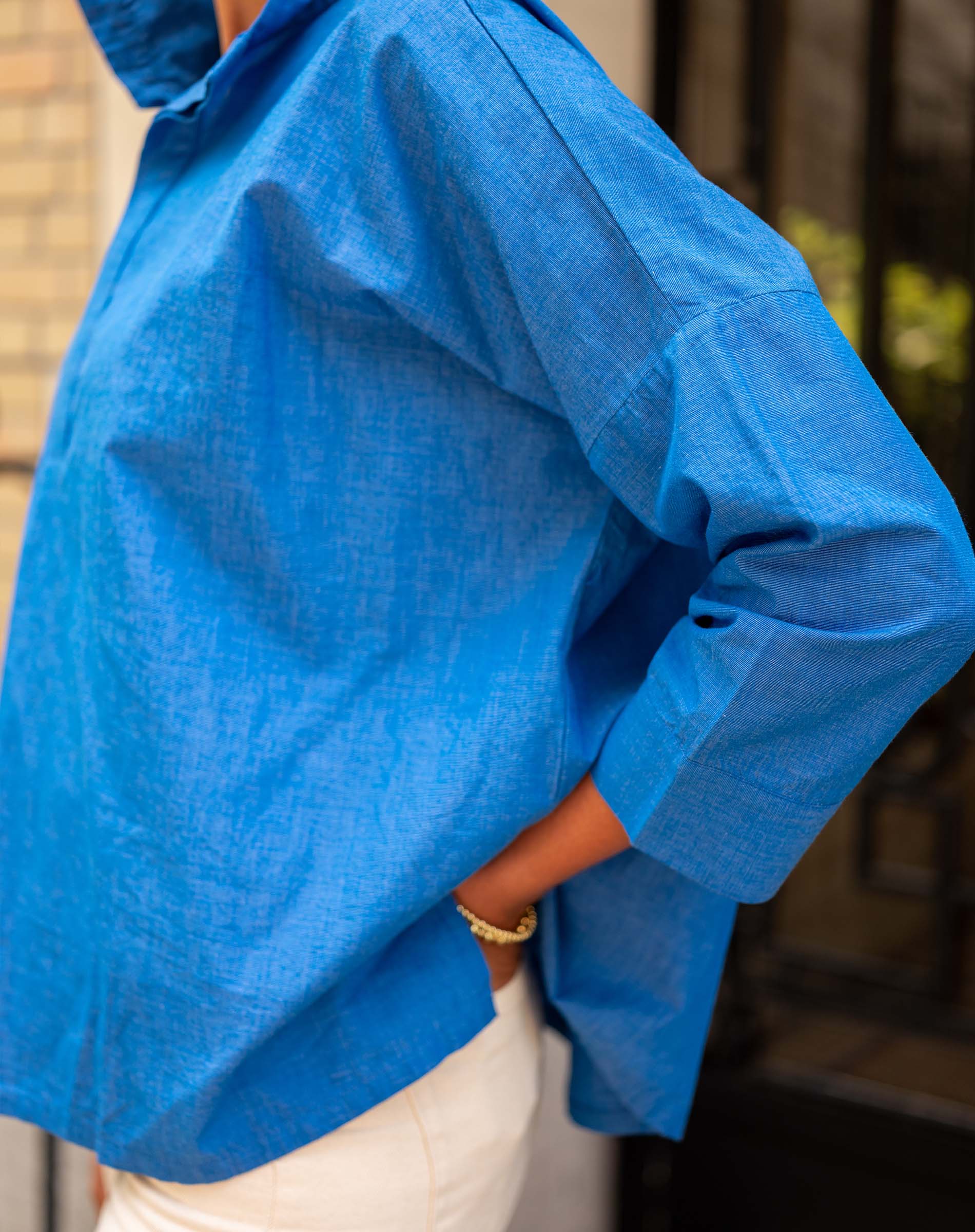 Person wearing a blue shirt with a blurred background