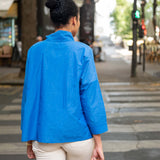 Person wearing a blue jacket walking on a city street