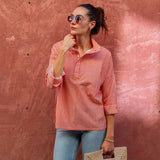 Woman wearing a red and white striped shirt against a textured pink wall