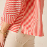 Red and white striped shirt worn by a person on a beige background