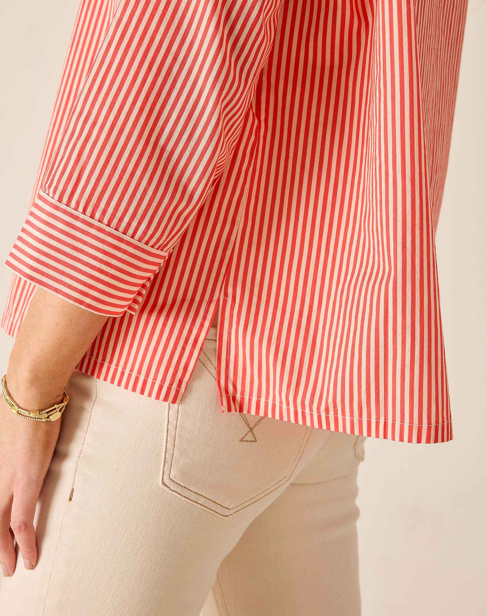 Red and white striped shirt worn by a person on a beige background