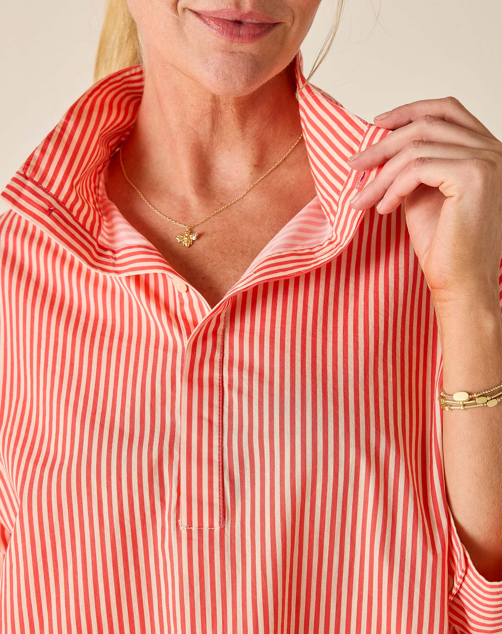 Person wearing a red and white striped shirt with a close-up of the collar.