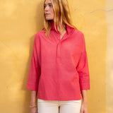 Woman wearing a pink shirt against a yellow wall