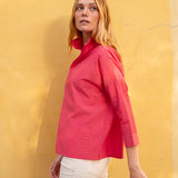 Woman wearing a red shirt against a yellow wall