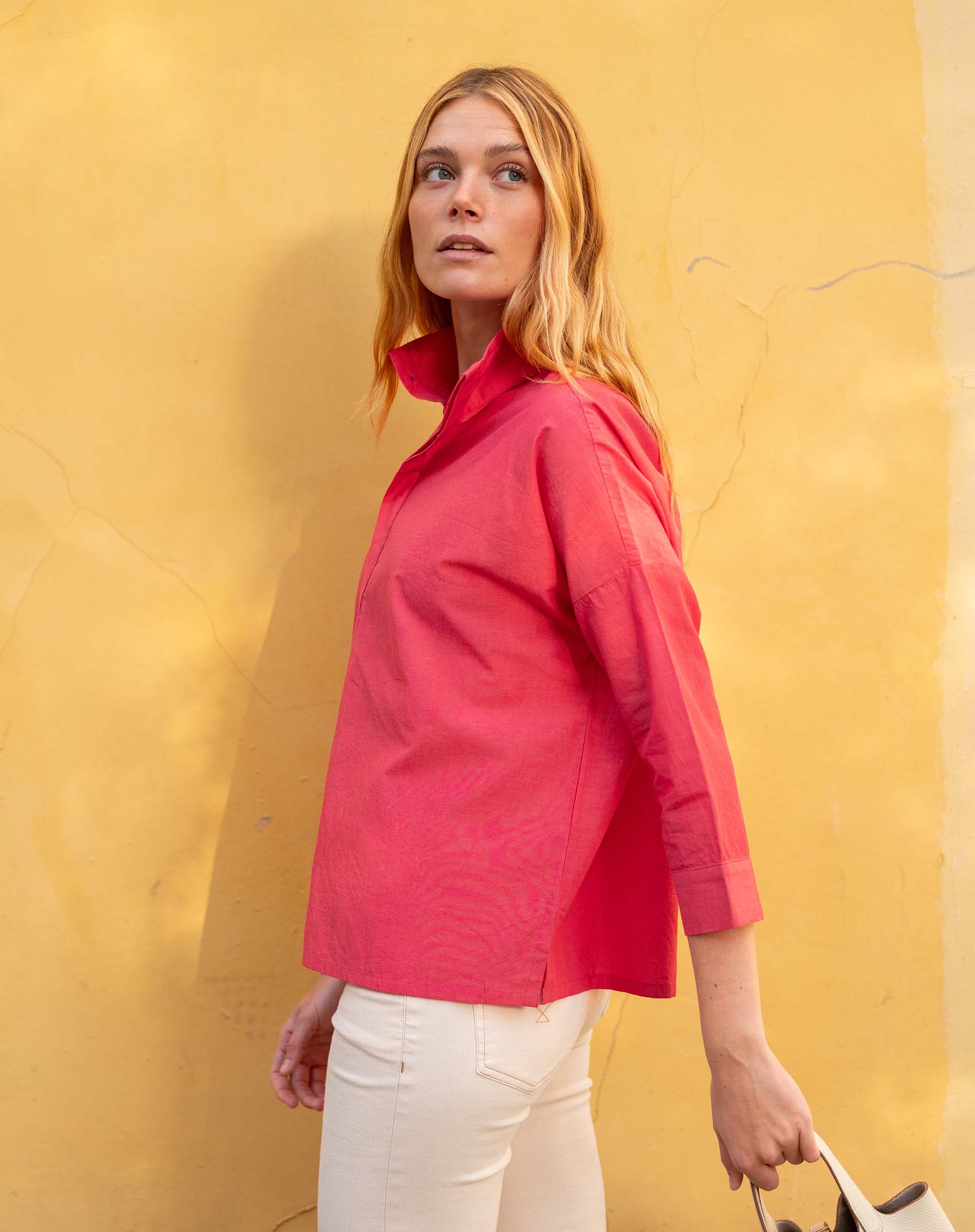Woman wearing a red shirt against a yellow wall