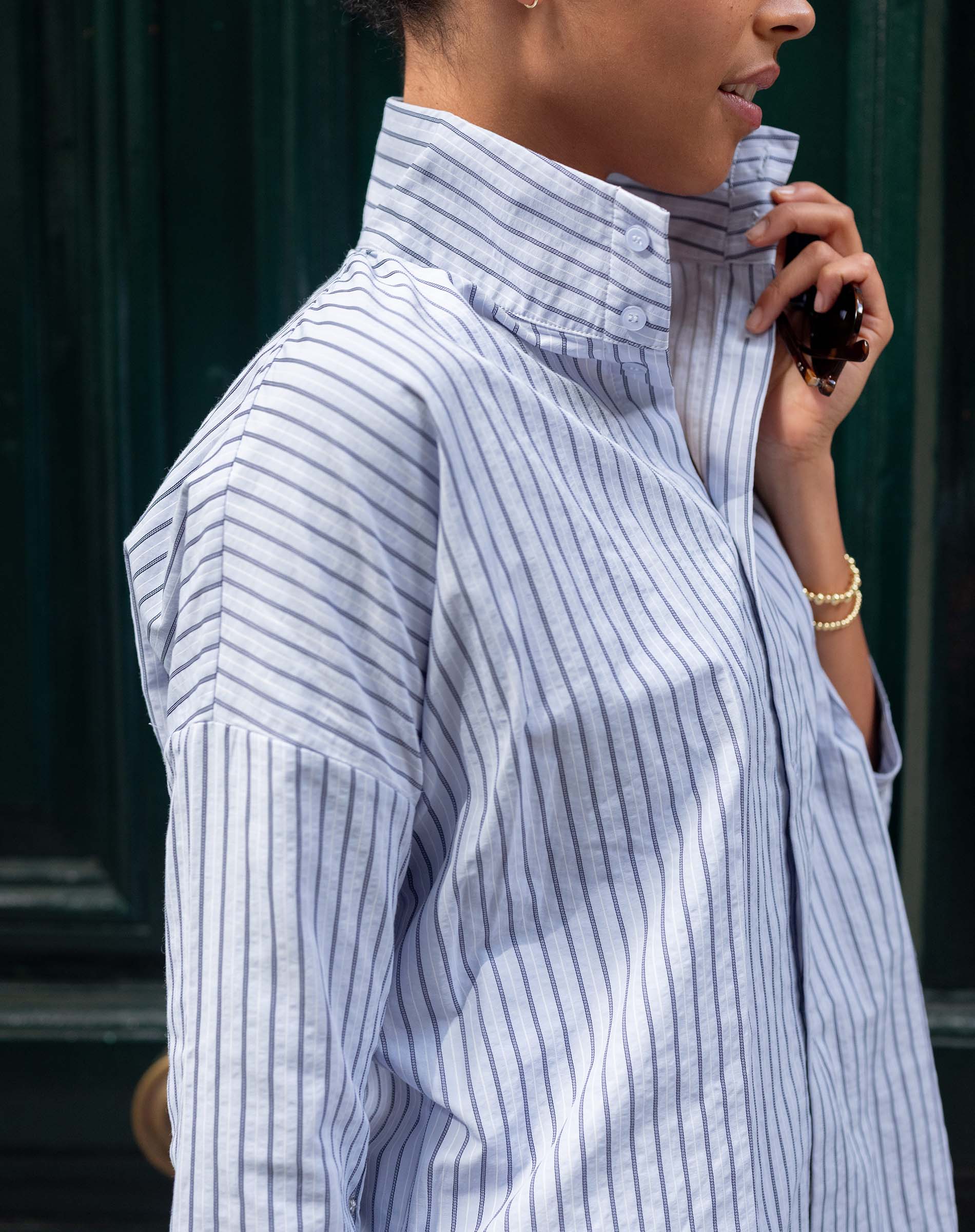 Person wearing a blue and white striped shirt with a blurred background