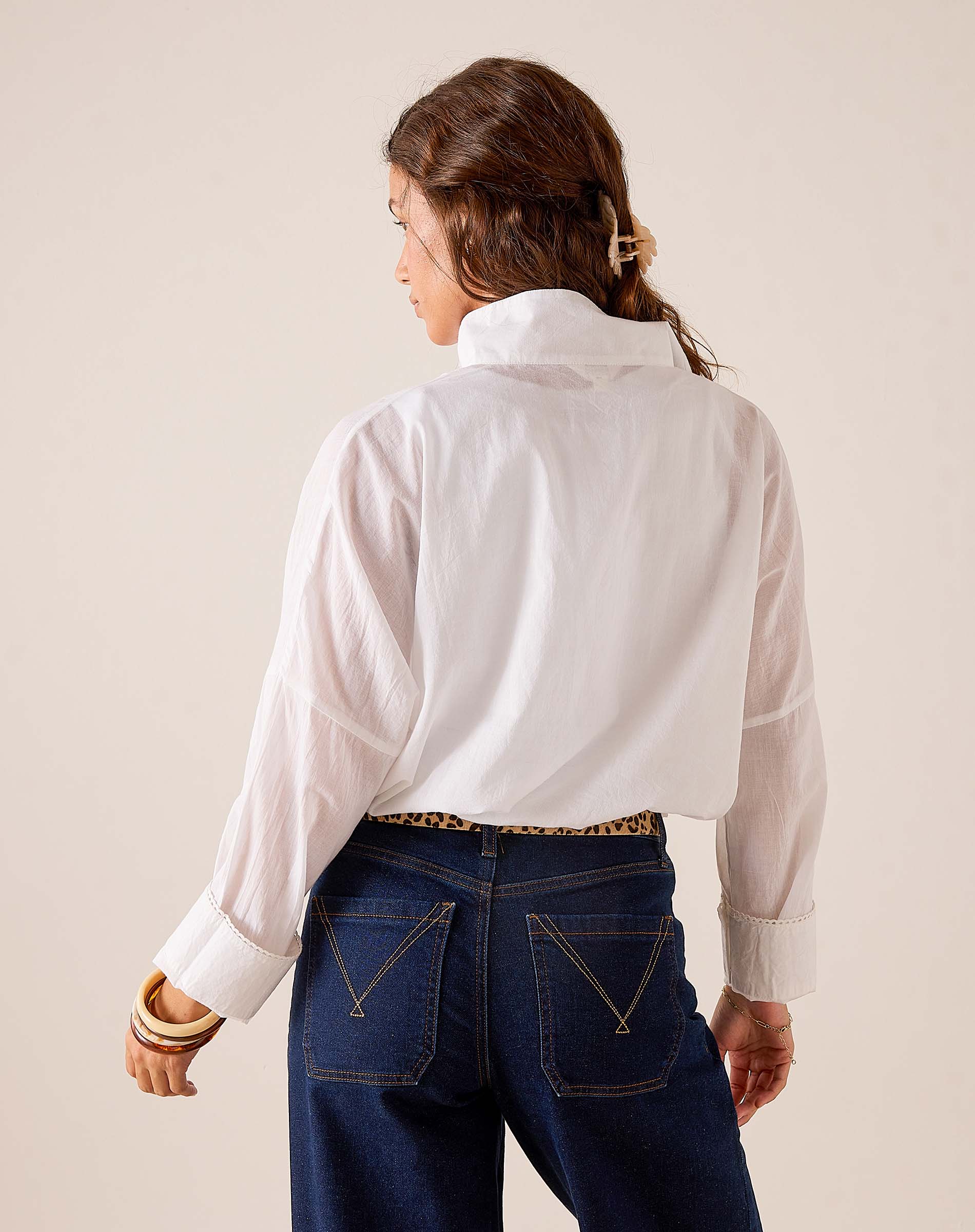 Back view of women's travel-friendly white oversized button-up cotton shirt with large cuffs.