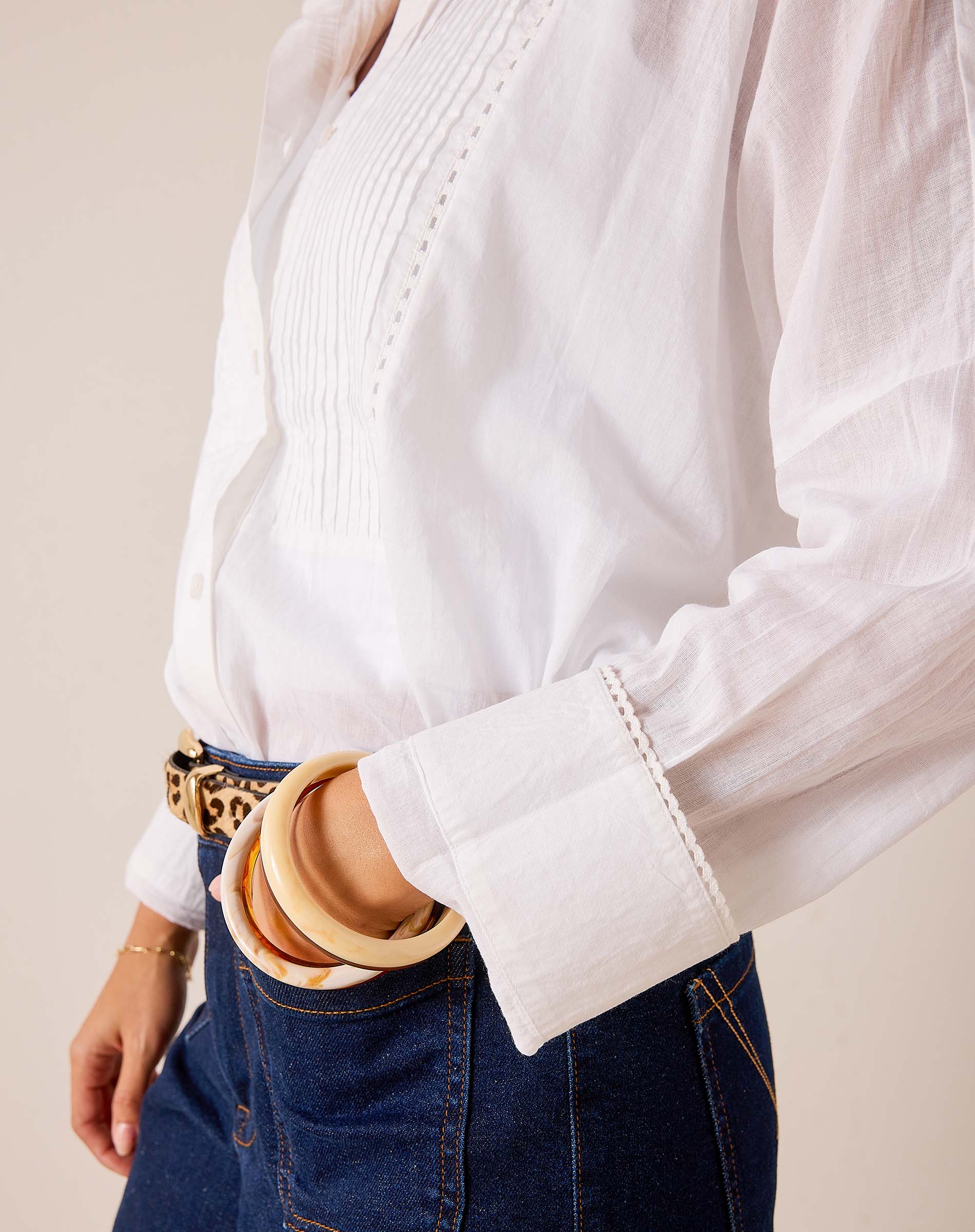 White tunic-style cotton top featuring pintuck detailing and a pleated front.