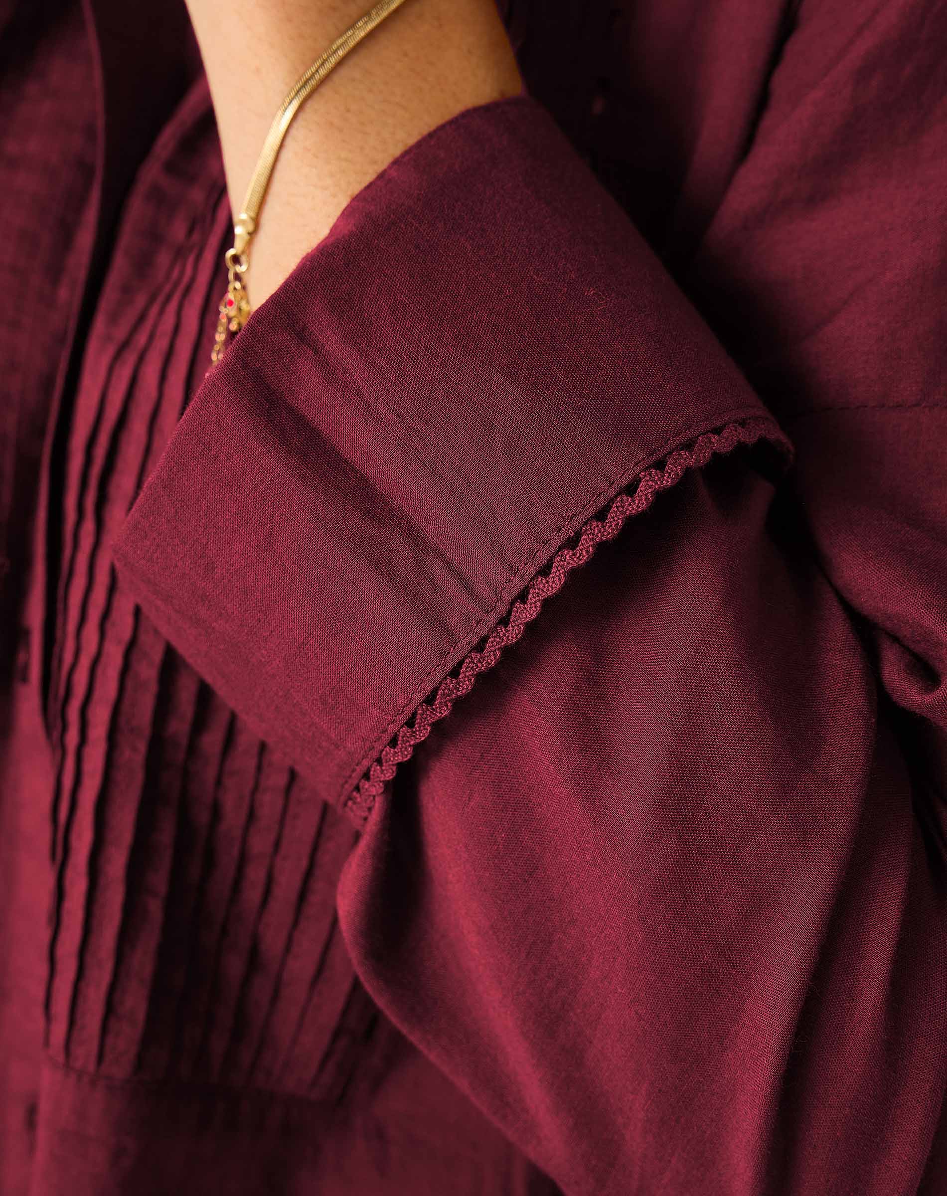 Burgundy tuxedo blouse with gathered detail and embroidered trim.