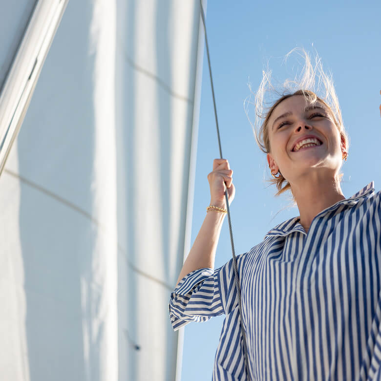 image of women sailing wearing a blue and white striped top