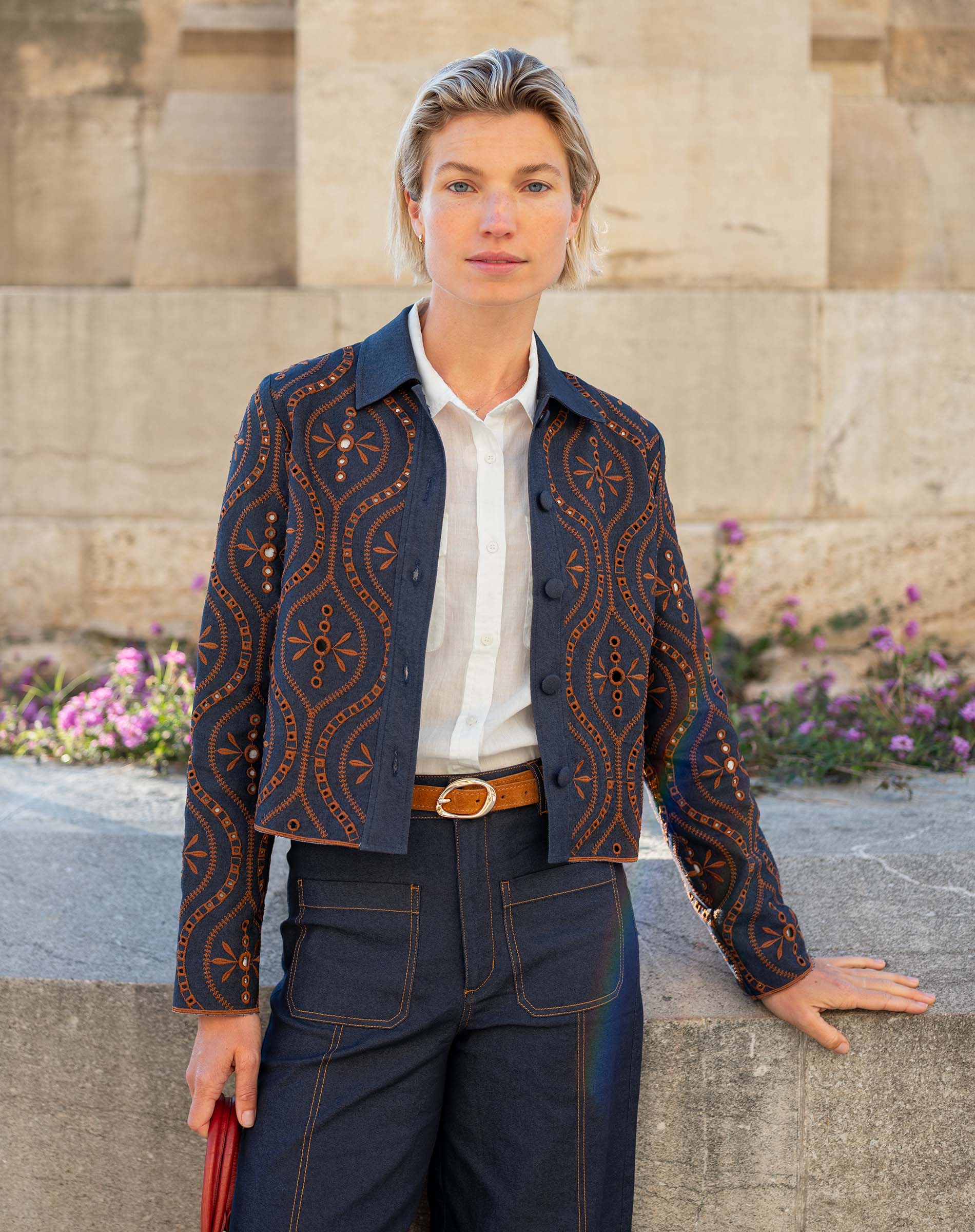 Women's travel-friendly rinse blue patterned button-front jacket with golden thread embroidery and a structured fit.