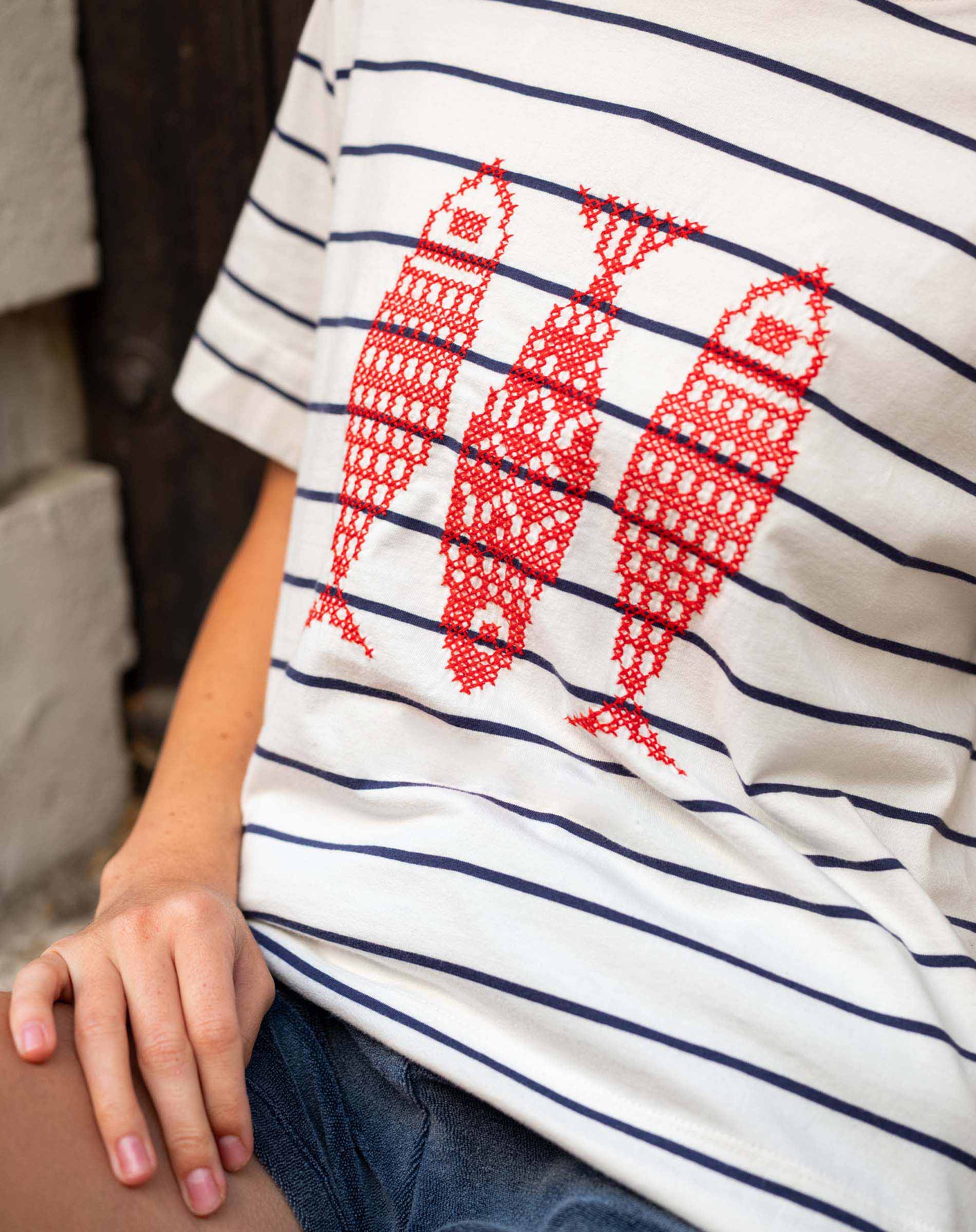 Close-up of a person wearing a striped shirt with red fish designs.