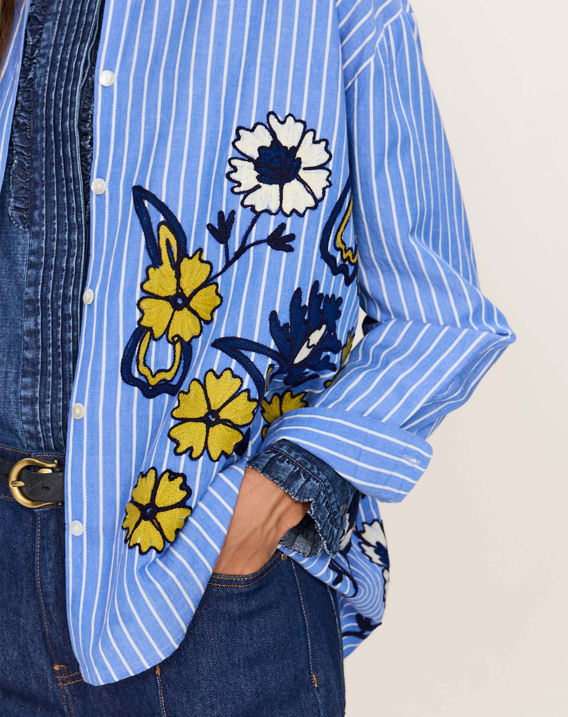 Blue and white striped cotton shirt with embroidered yellow and white floral details and button-down front.