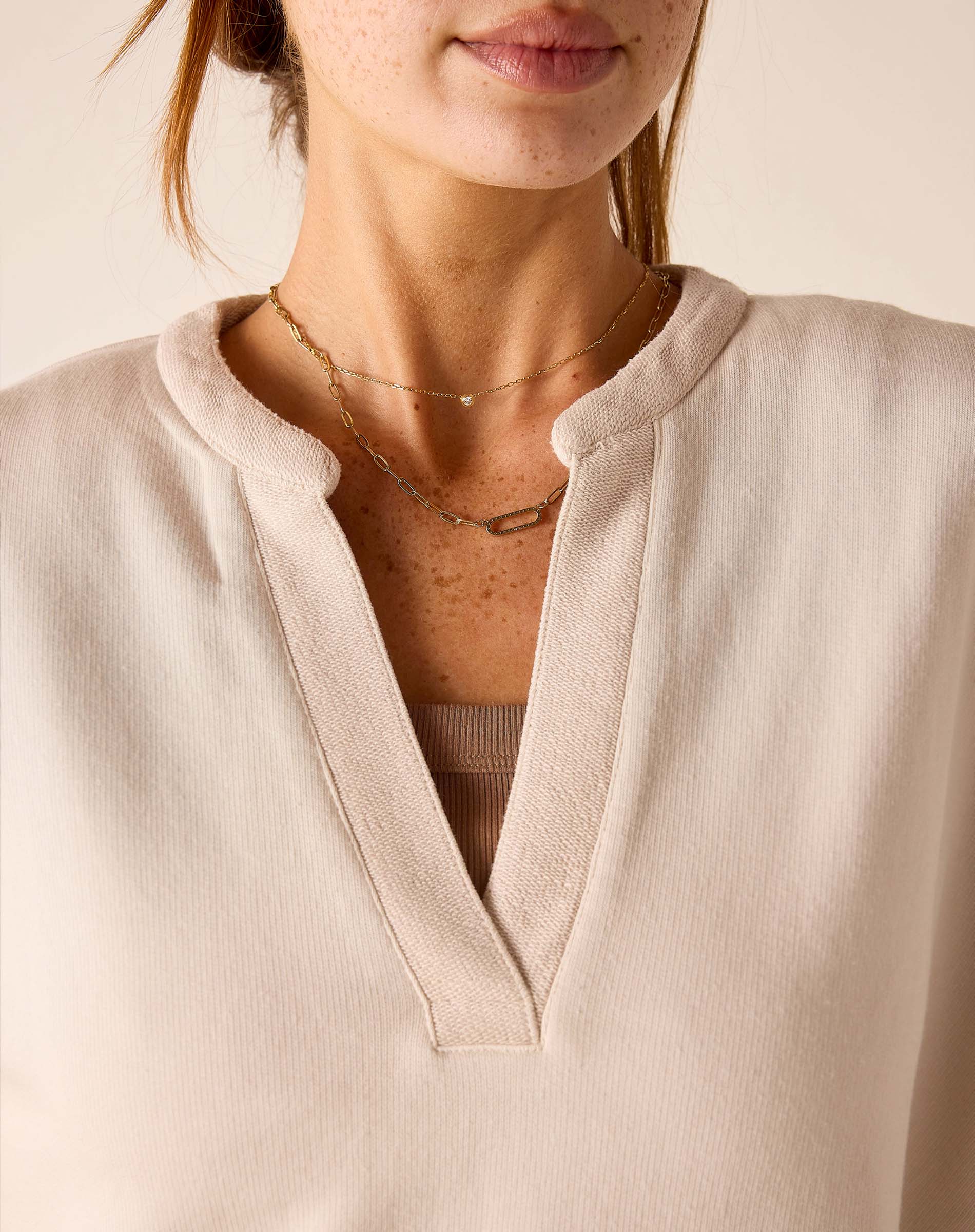 Bone knit top with a wide V-neckline and ribbed trim