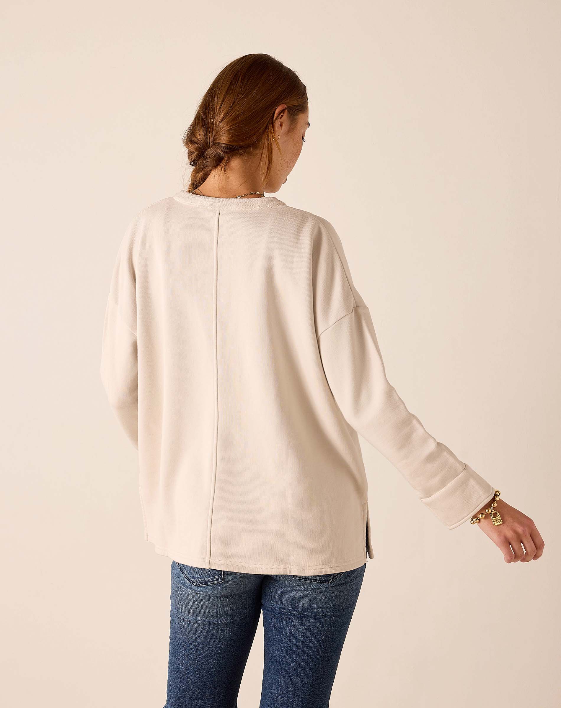 Back view of the bone knit top with dropped shoulders and long sleeves.