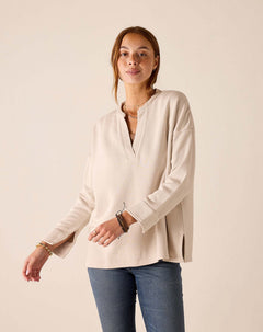 Bone-colored tunic top with a split neckline and wide ribbed cuffs.