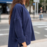 Woman wearing a blue oversized sweatshirt on a city street