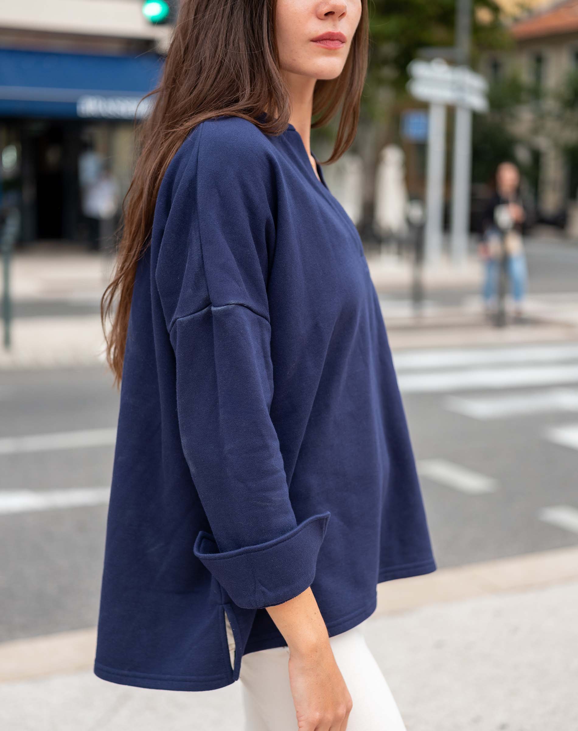 Woman wearing a blue oversized sweatshirt on a city street
