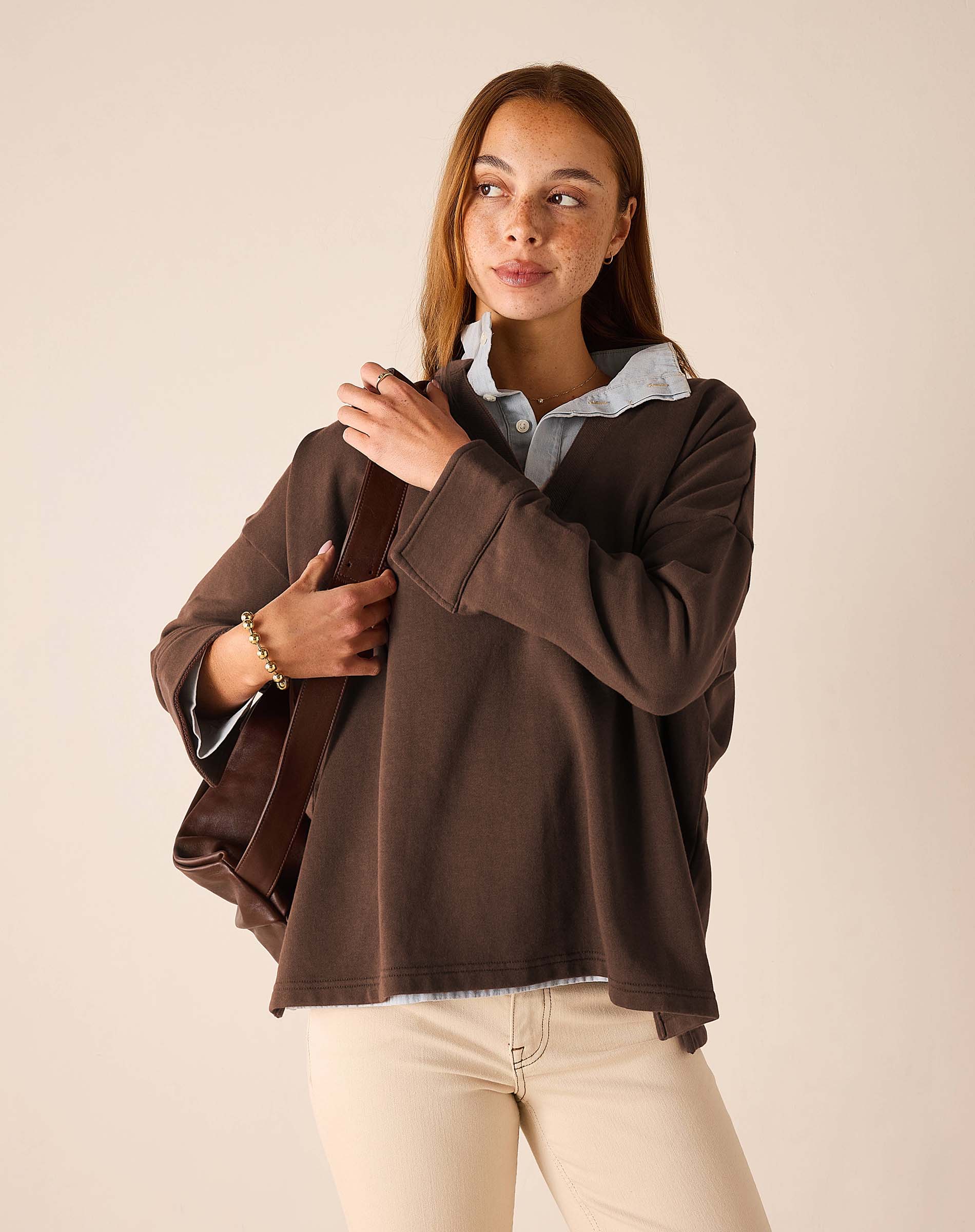 MERSEA ladies' travel-ready espresso brown knit top with wide ribbed cuffs and a layered white shirt collar.