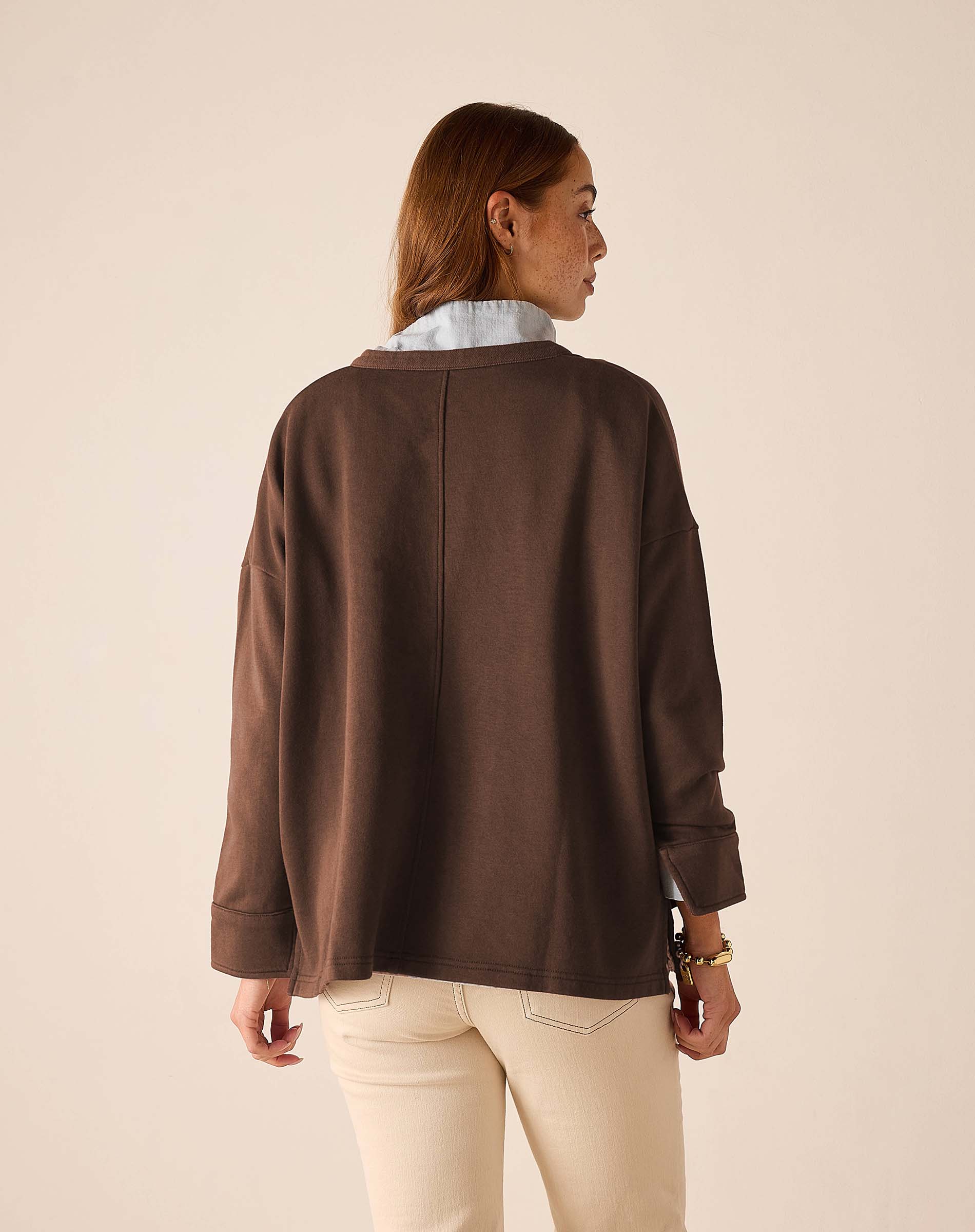 Back view of the espresso knit top with dropped shoulders and wide cuffs.