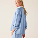 Woman wearing a light blue outfit against a plain background