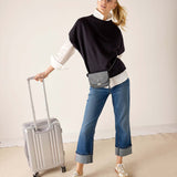MERSEA ladies' travel-ready black dolman top with white contrast trim and wide sleeves over denim jeans.