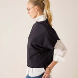 Side view of women's travel-friendly black dolman top over a white button-down shirt.