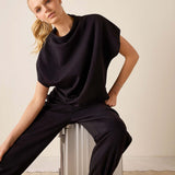 Black dolman top with dropped shoulders and wide-leg pants.