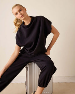 Black dolman top with dropped shoulders and wide-leg pants.