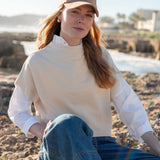 MERSEA ladies' travel-ready bone dolman top over a white collared shirt with blue denim jeans.