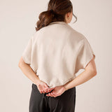 Back view of women's travel-friendly bone-colored dolman top with relaxed fit and soft knit construction.