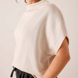 Bone colored dolman sleeve knit top with high neckline and relaxed fit.