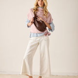 Woman holding a brown leather bag against a plain background