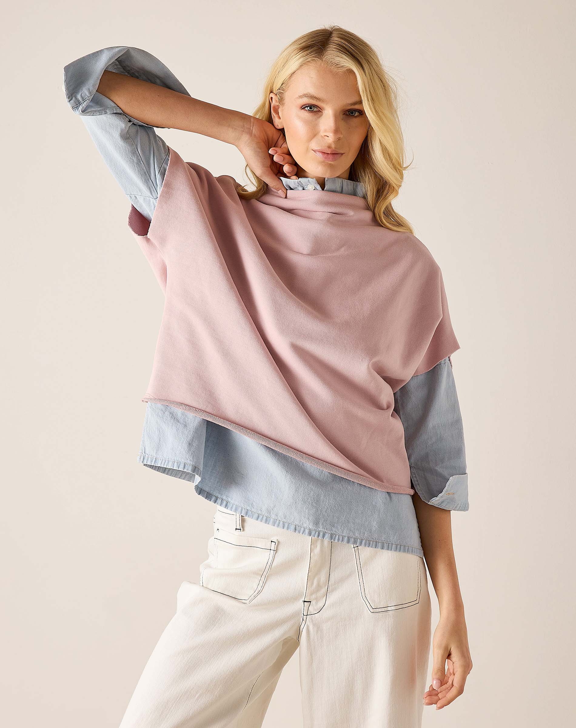 Woman wearing a pink scarf over a light blue shirt with a beige background