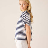 Woman wearing a navy and white striped shirt against a plain background