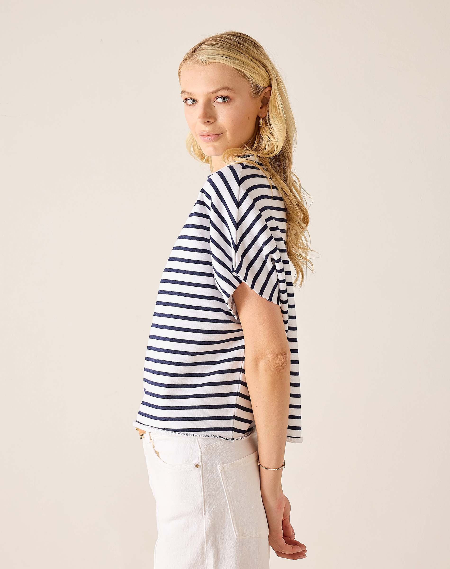 Woman wearing a navy and white striped shirt against a plain background